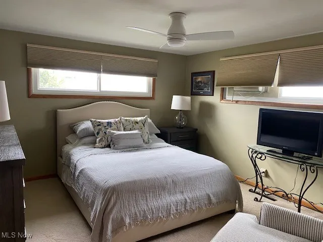 Bedroom with carpet, multiple windows, and ceiling fan