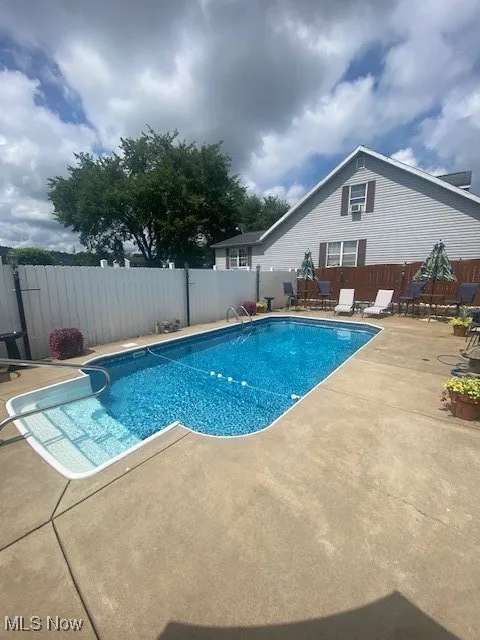 View of swimming pool with a patio area and a fenced backyard