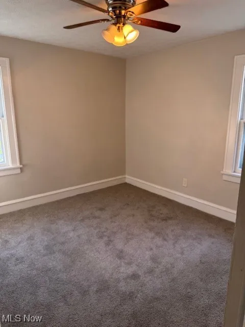 Unfurnished room with a ceiling fan and carpet flooring