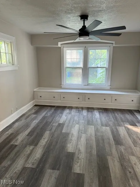 Spare room featuring a ceiling fan, a textured ceiling, and wood finished floors