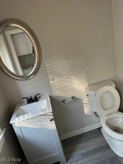 Half bath with vanity and wood finished floors