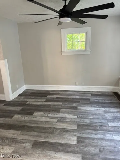 Empty room with wood finished floors and a ceiling fan