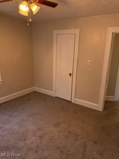 Unfurnished room with carpet and a ceiling fan
