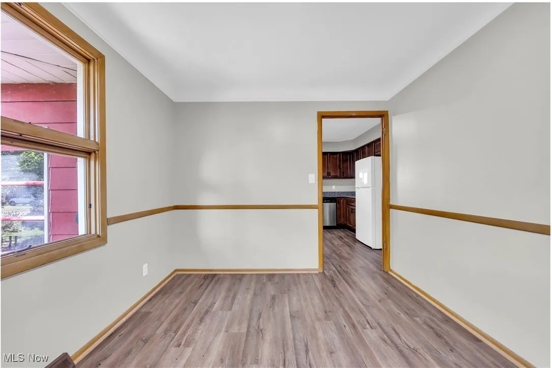 Spare room featuring light wood finished floors and baseboards