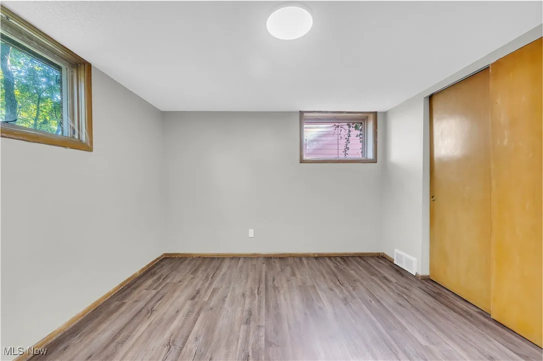 Below grade area featuring light wood-type flooring and plenty of natural light