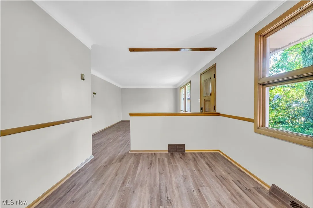 Unfurnished room featuring light wood finished floors and ornamental molding