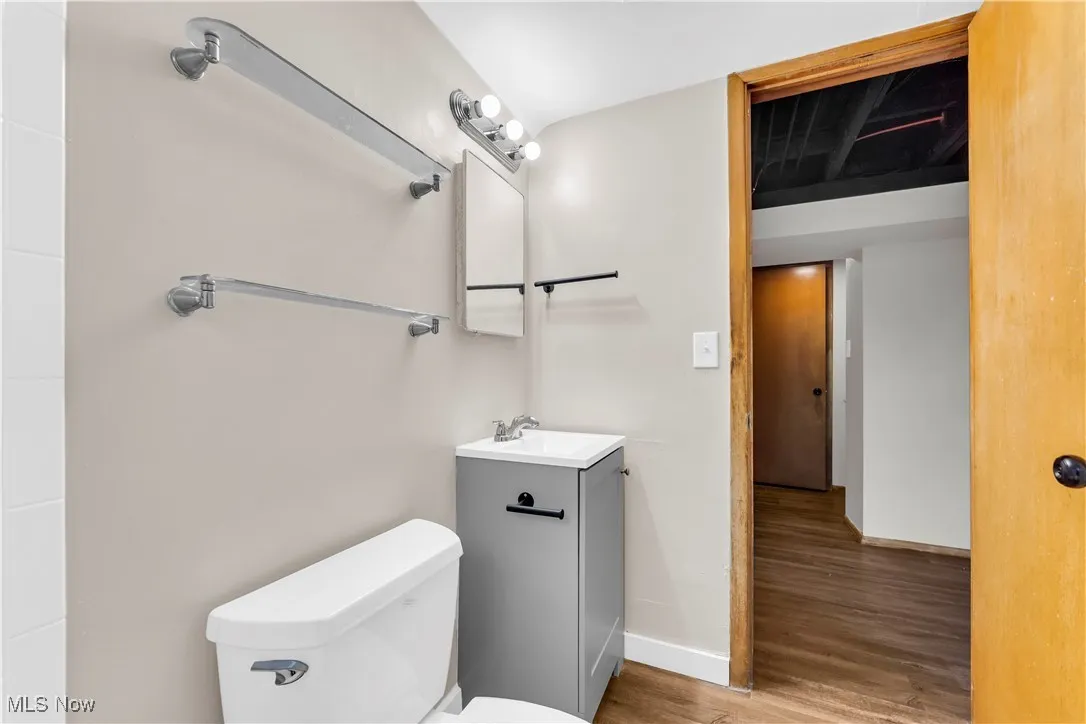 Half bathroom with vanity and wood finished floors
