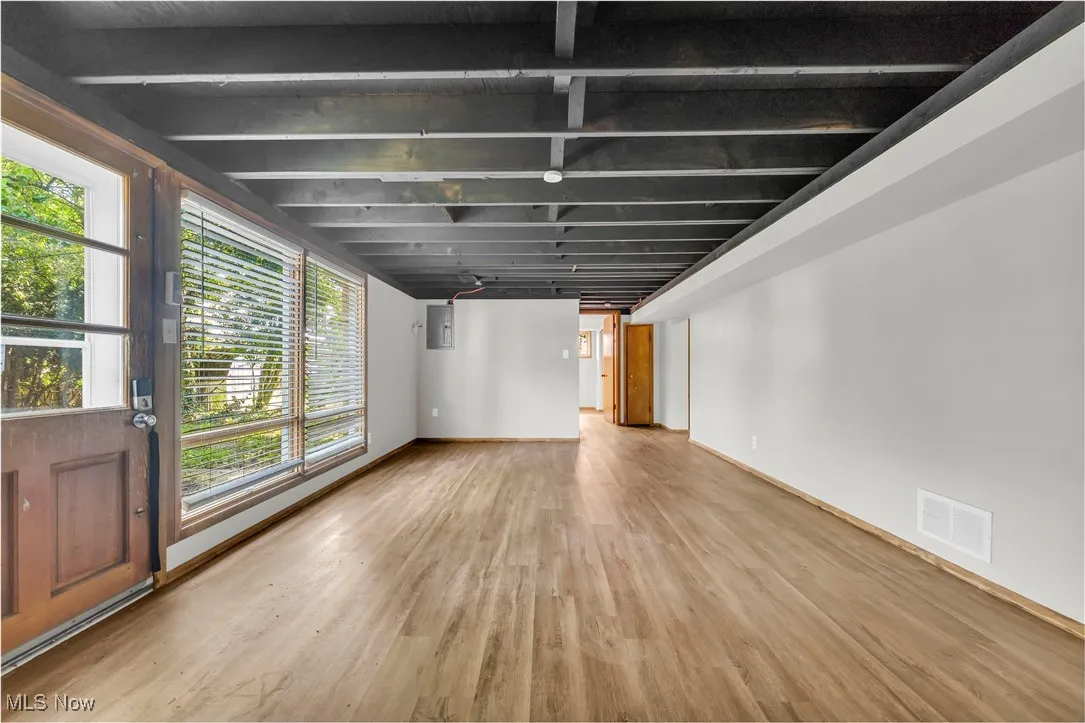 Unfurnished living room with wood finished floors and electric panel