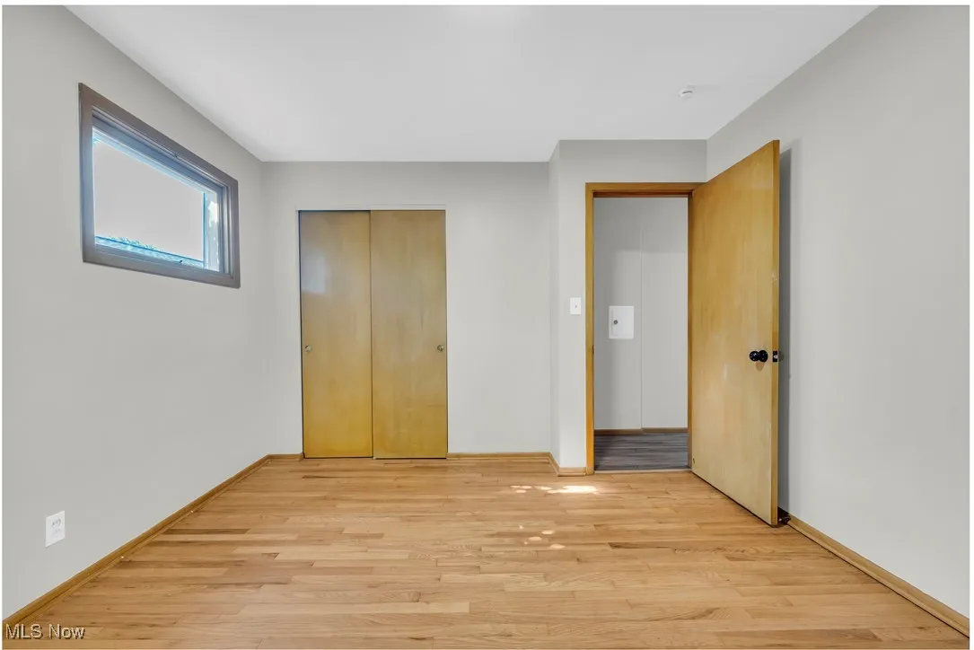 Unfurnished bedroom featuring light wood-style flooring and a closet