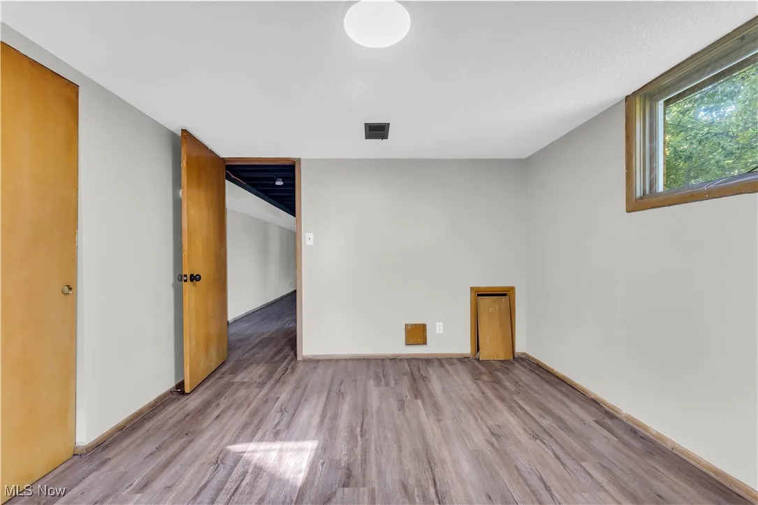 Unfurnished room featuring wood finished floors and baseboards
