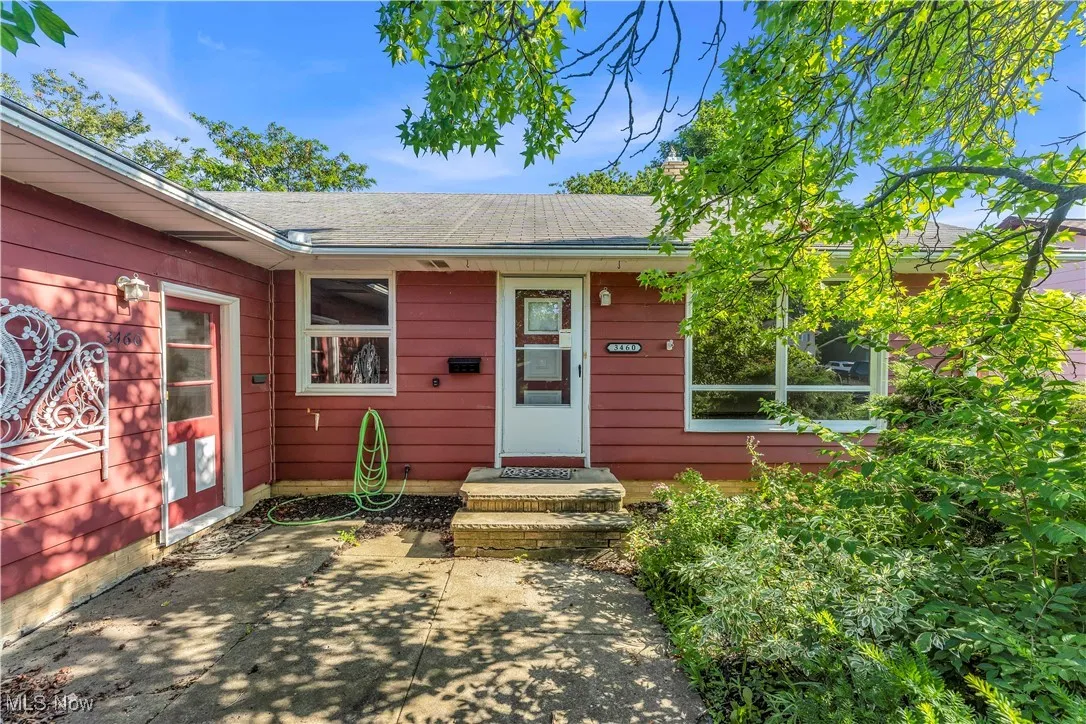 Doorway to property featuring roof with shingles