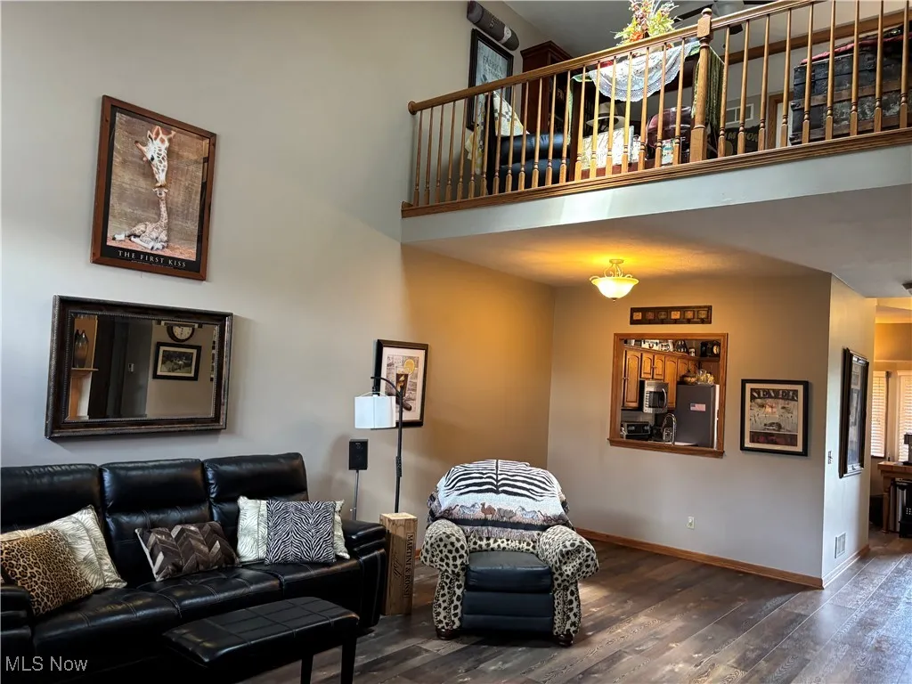 Living area featuring wood finished floors and a towering ceiling