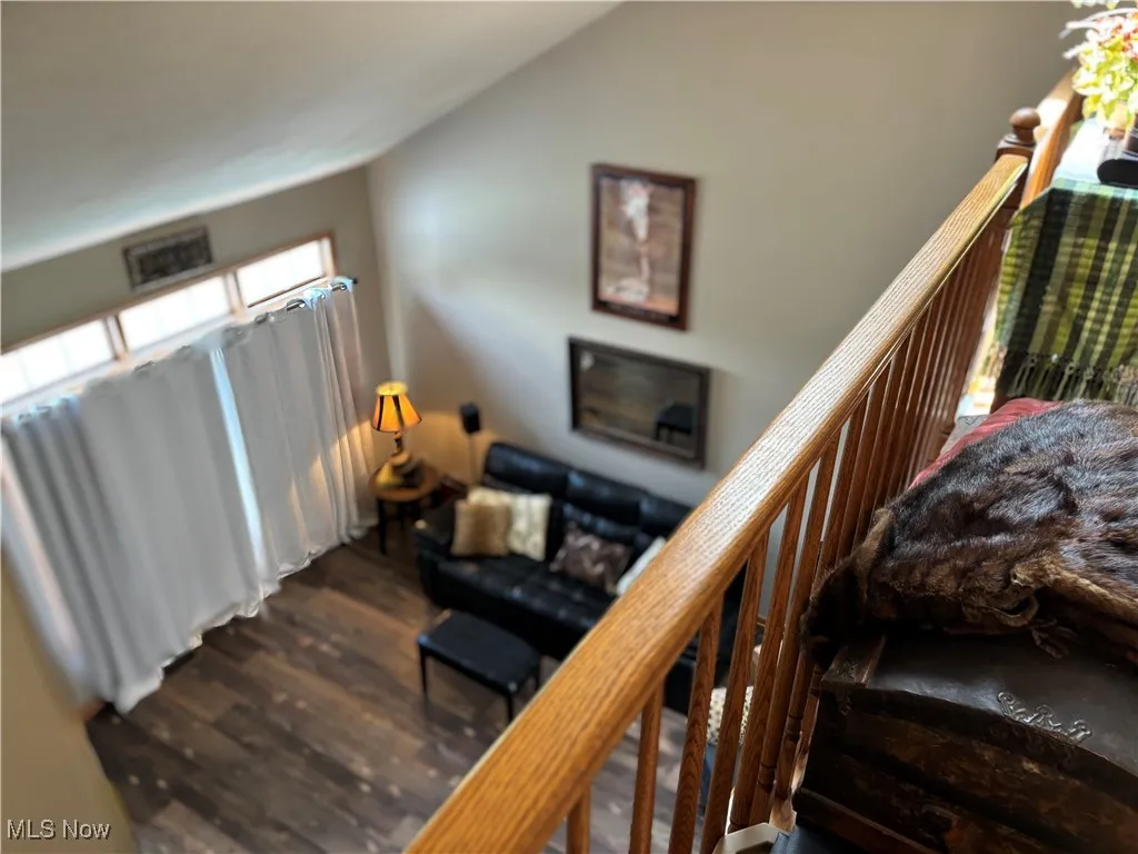 Stairs featuring wood finished floors and lofted ceiling