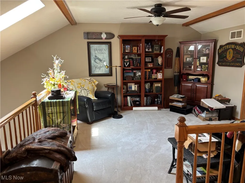 Living area with a ceiling fan and light colored carpet
