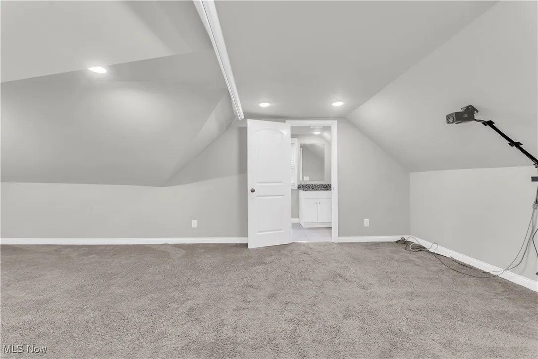 Additional living space featuring carpet floors, vaulted ceiling, and recessed lighting