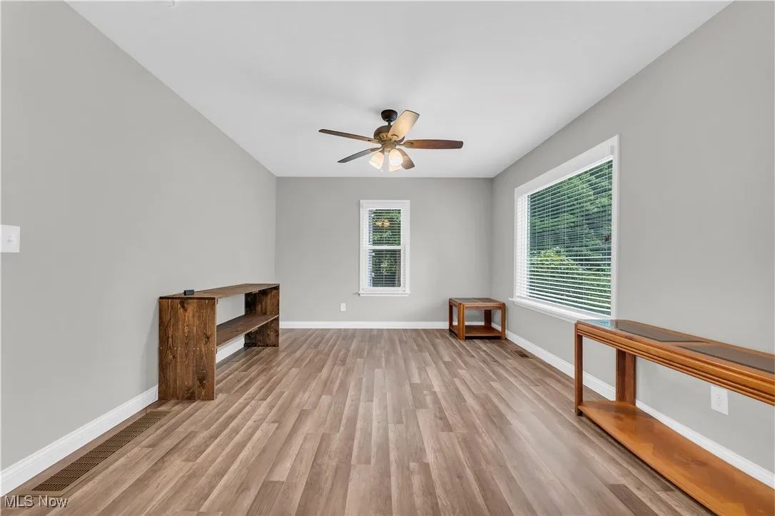 Empty room featuring ceiling fan and light wood-style floors