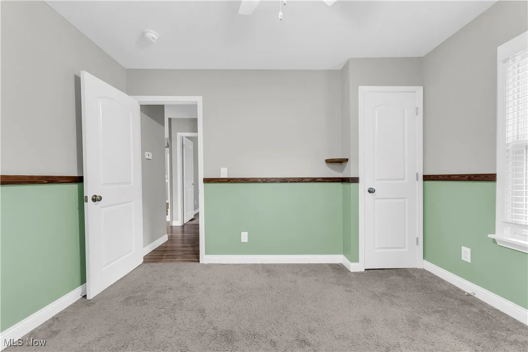Empty room with carpet and ceiling fan