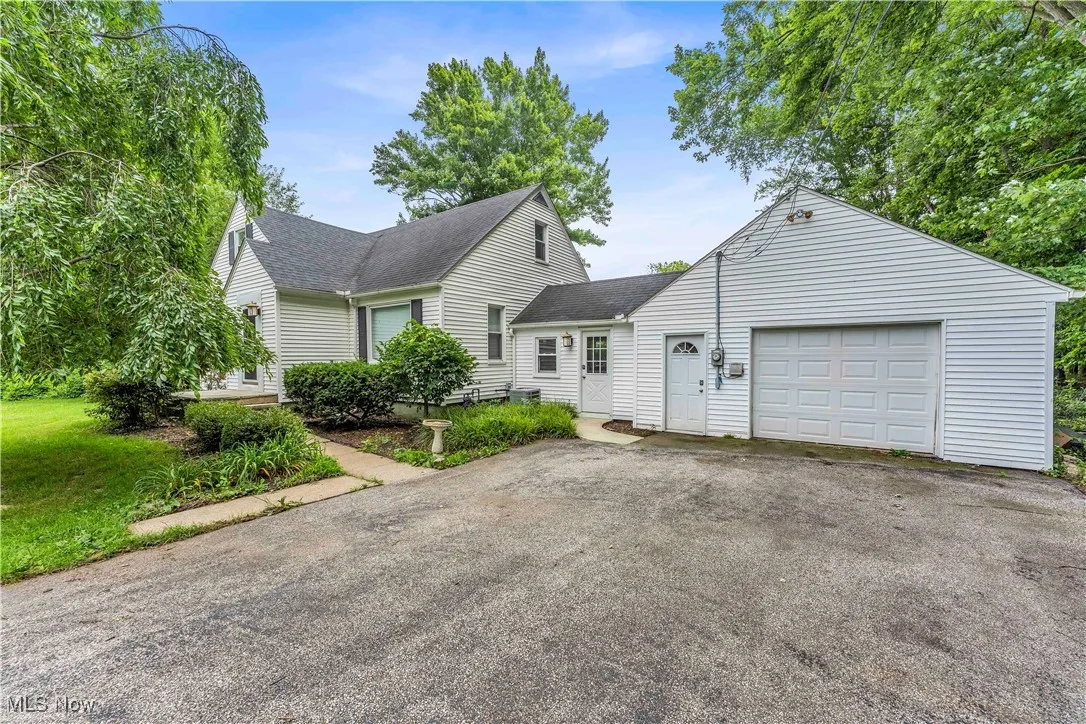 View of front of house featuring a shingled roof, asphalt driveway, and an attached garage