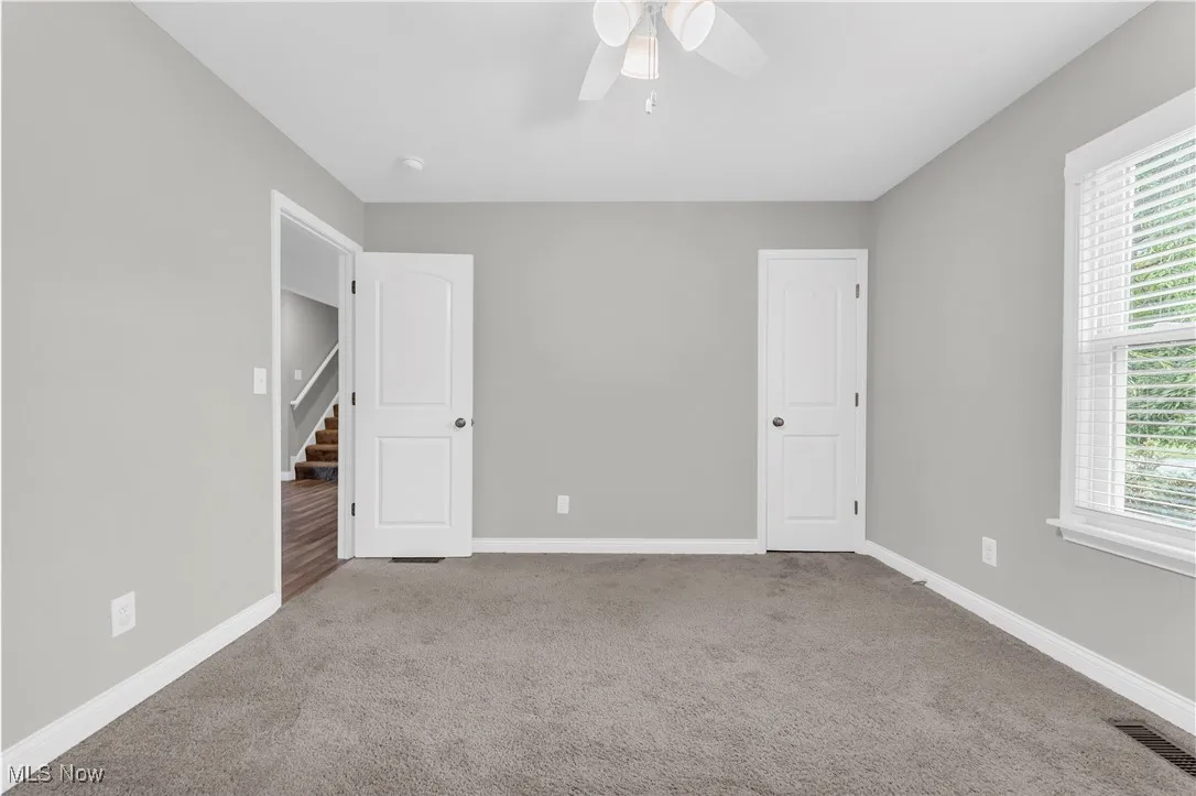Unfurnished bedroom featuring carpet floors and a ceiling fan