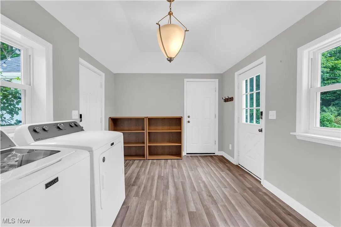 Laundry room with independent washer and dryer and light wood finished floors