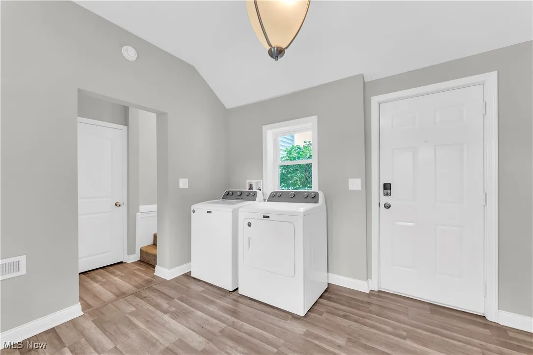 Washroom featuring washer and clothes dryer and light wood finished floors
