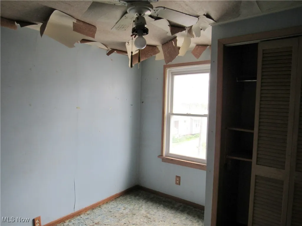 Unfurnished bedroom featuring light carpet and baseboards