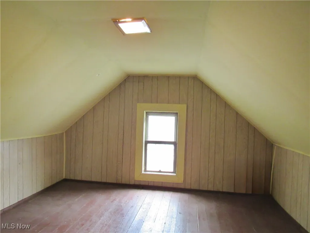 Bonus room featuring wood-type flooring and lofted ceiling