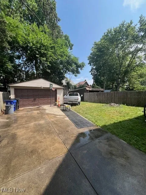 View of yard with a detached garage and an outbuilding