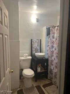 Full bath with toilet and curtained shower