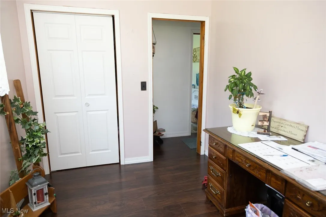 Office with dark wood-style floors and baseboards