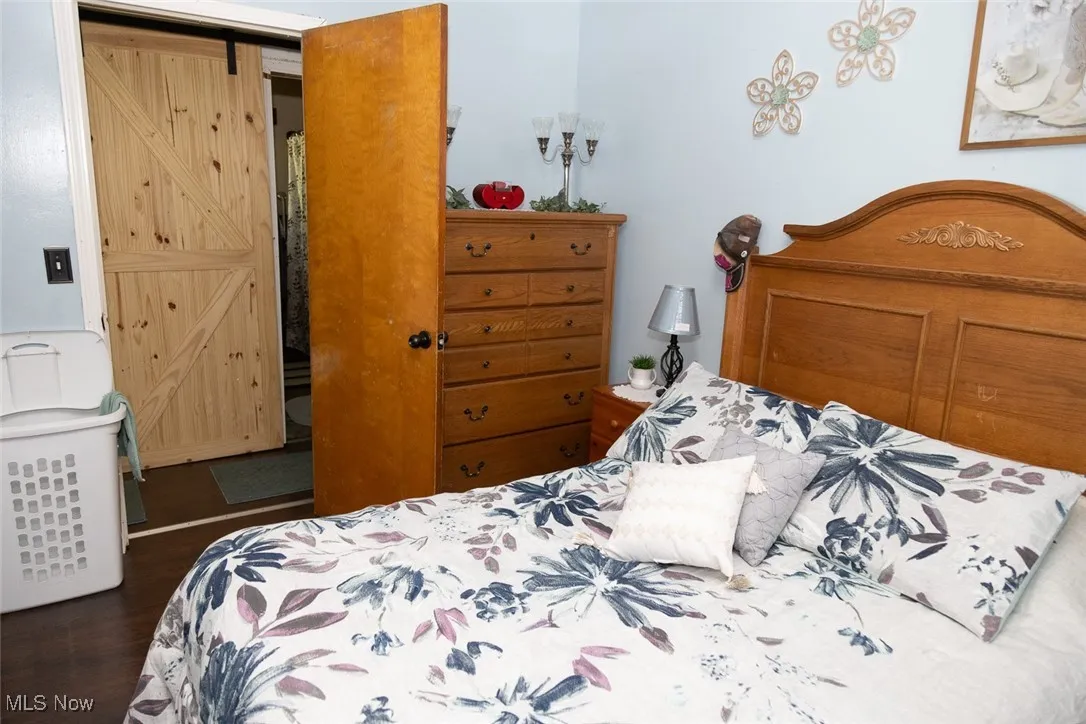 Bedroom with a barn door and wood finished floors