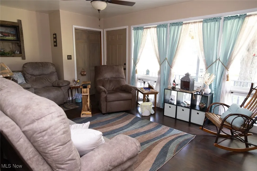 Living room with dark wood-style flooring and ceiling fan