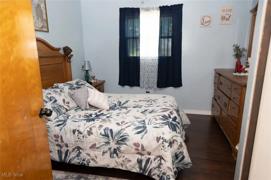 Bedroom with wood finished floors and baseboards