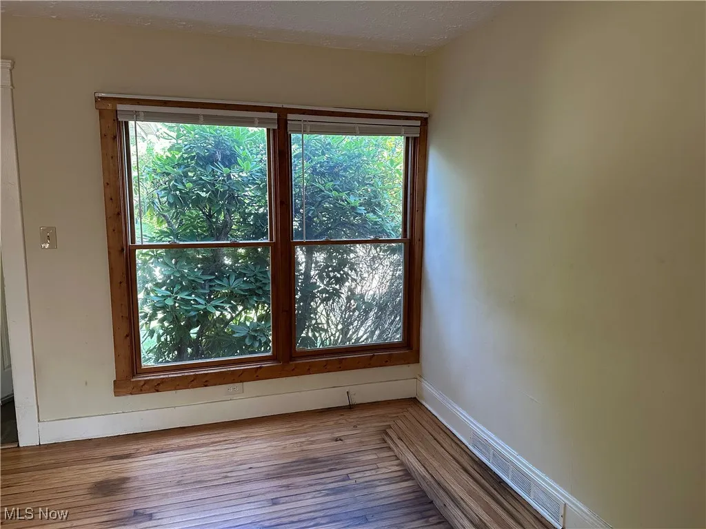 Spare room featuring wood finished floors
