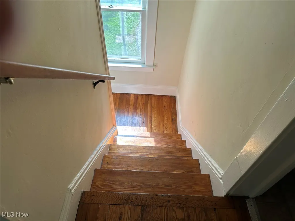 Staircase with baseboards and wood finished floors