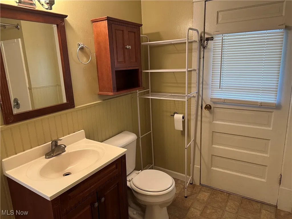 Bathroom featuring wainscoting, vanity, and a shower