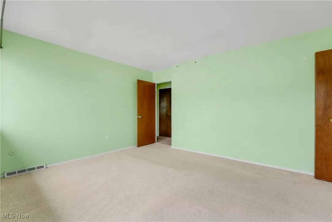 Carpeted empty room with baseboards