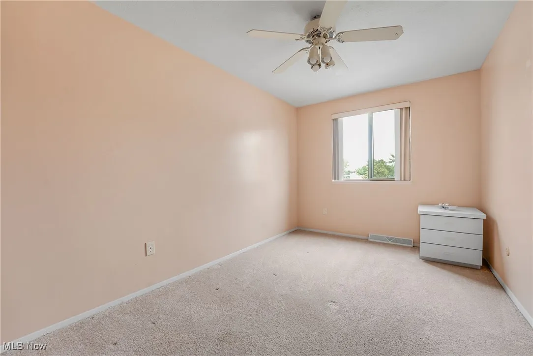 Carpeted empty room with baseboards and ceiling fan