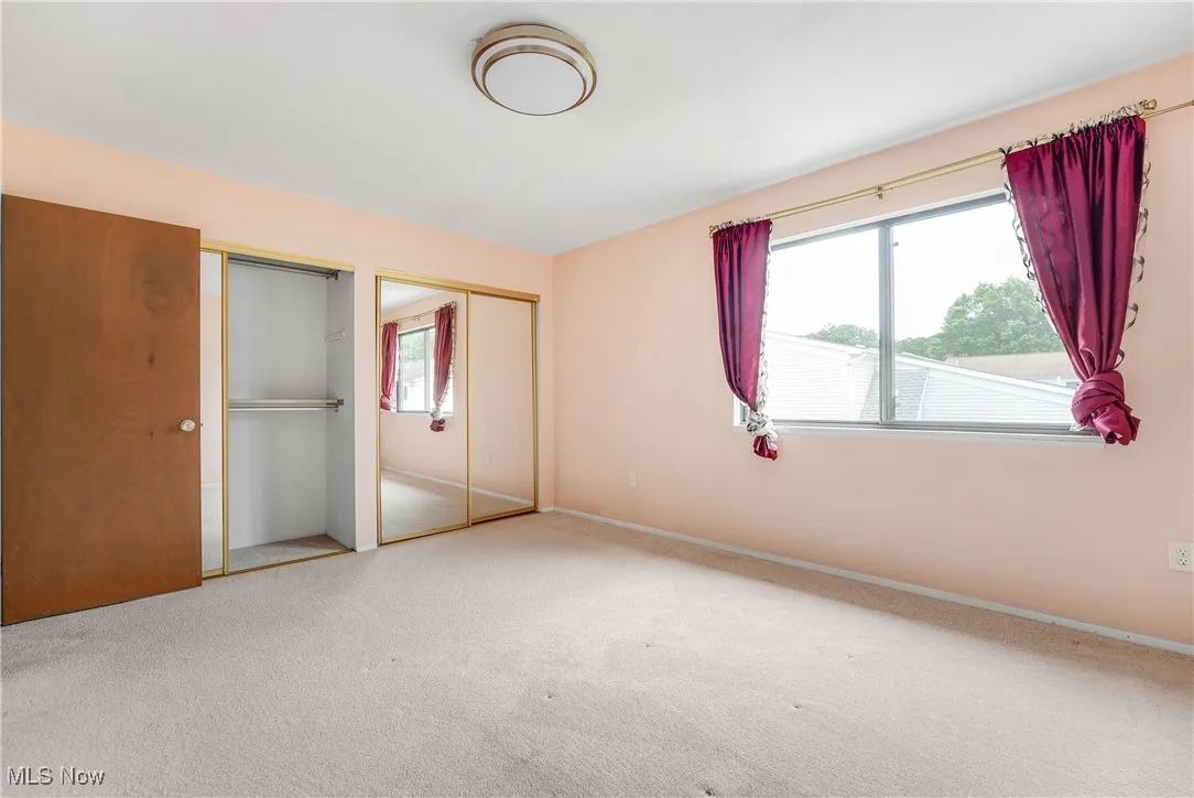 Unfurnished bedroom with two closets and carpet floors