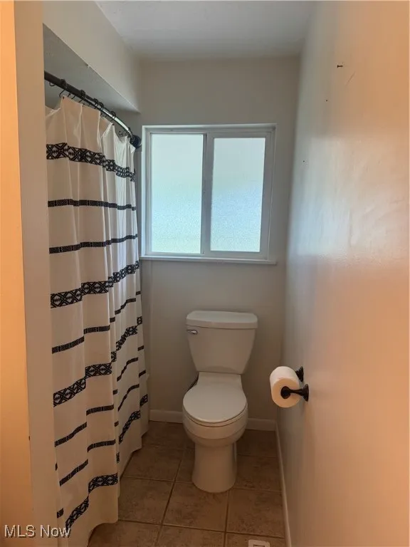 Bathroom featuring tile patterned floors and a shower with curtain