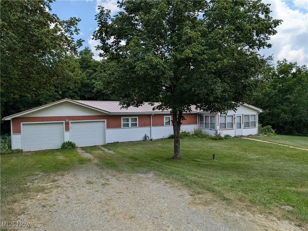 Single story home with driveway, a front lawn, and a garage