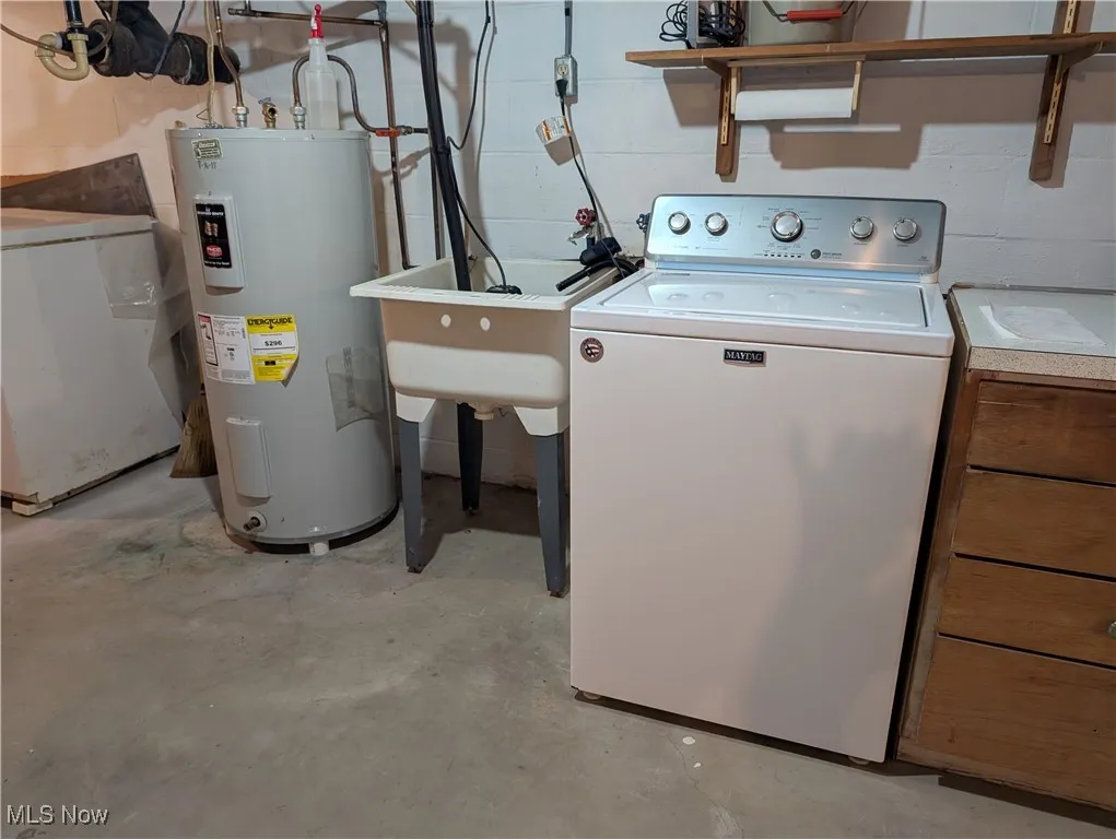 Laundry area with washer / clothes dryer, water heater, and concrete block wall