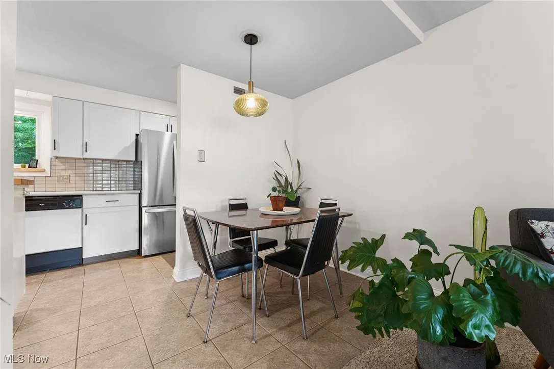Dining space featuring light tile patterned floors and baseboards