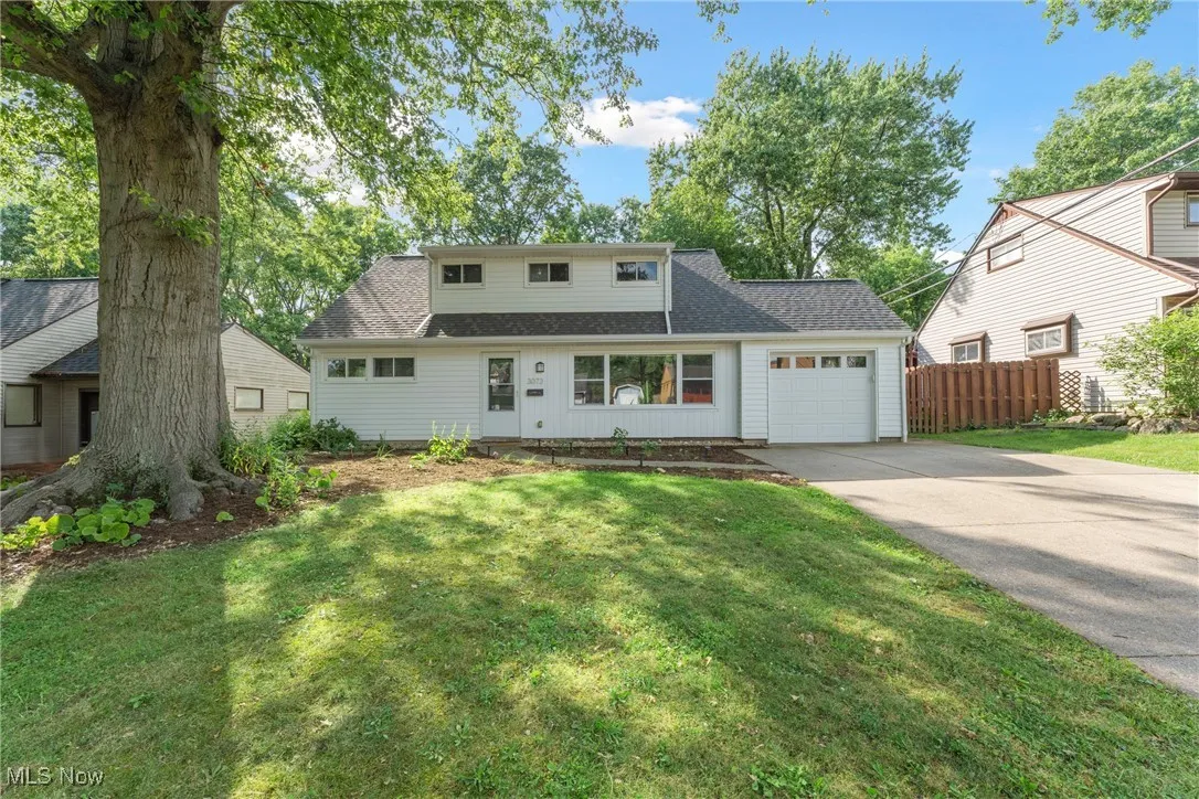 View of front of house with an attached garage, driveway, and roof with shingles