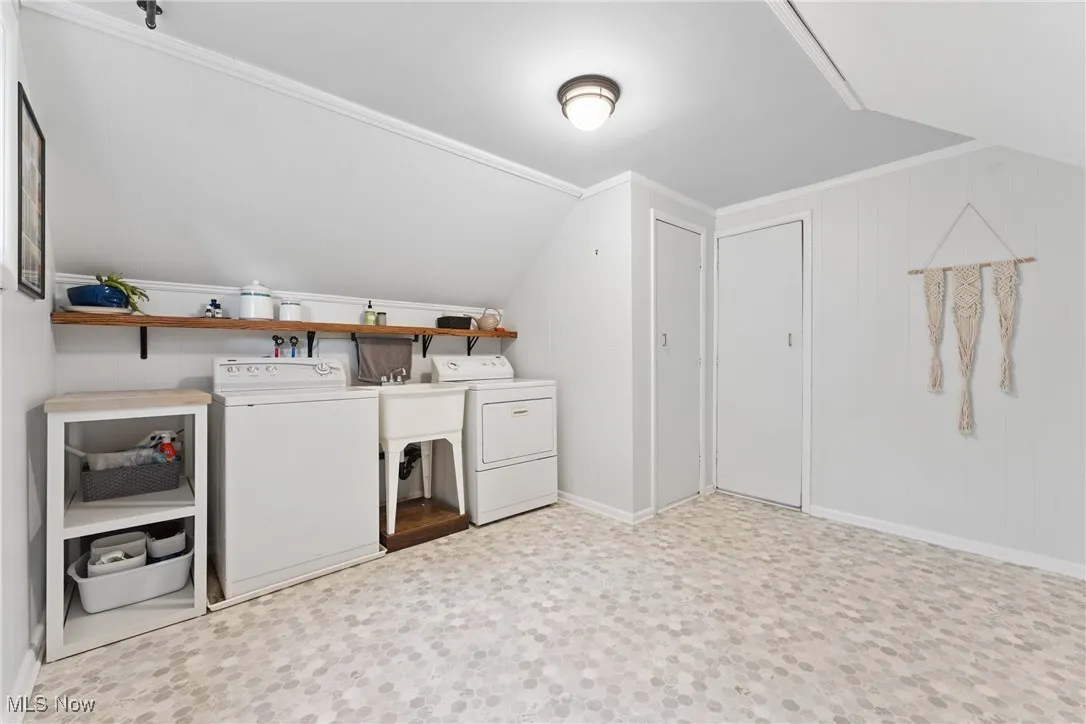 Laundry room with washing machine and dryer and tile patterned floors