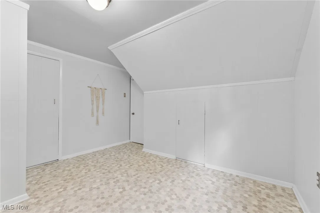 Bonus room featuring baseboards and lofted ceiling