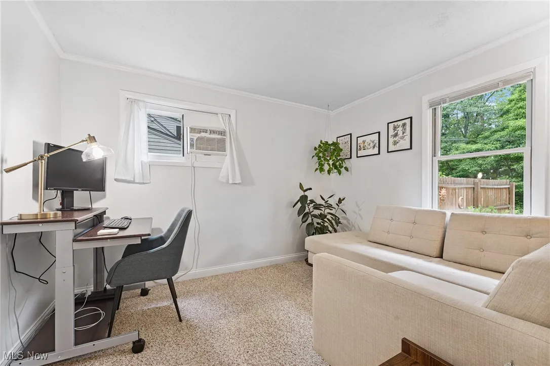 Carpeted home office with ornamental molding and a wall mounted AC