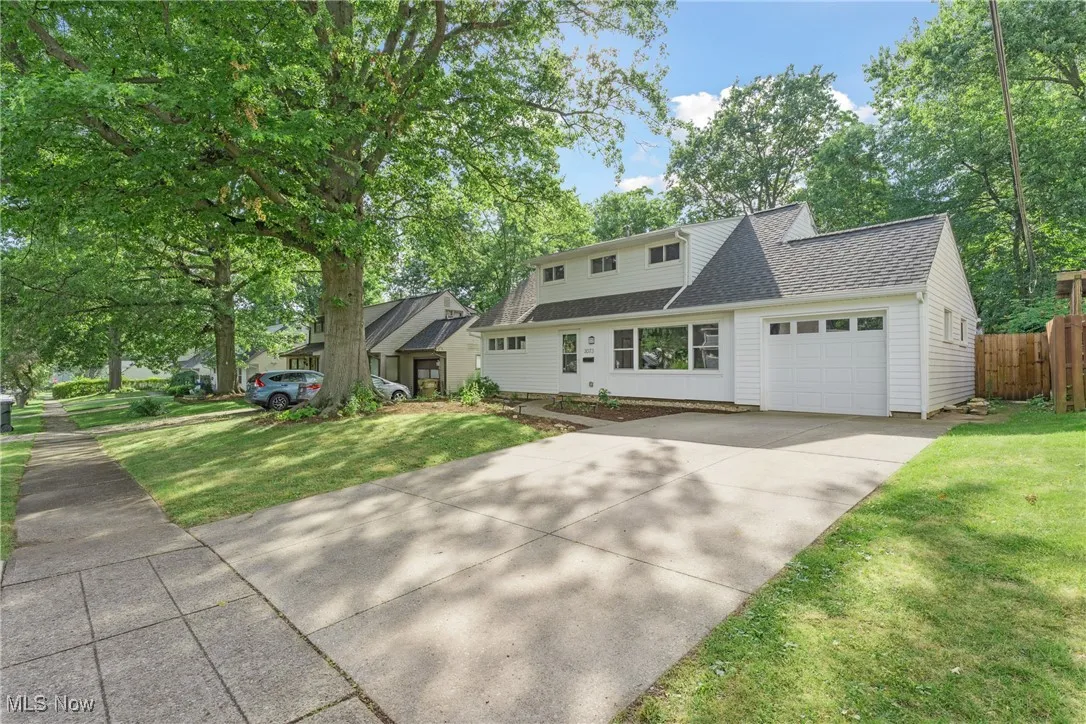 View of front facade with a garage, a shingled roof, and concrete driveway