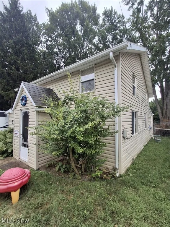 View of side of home with a yard