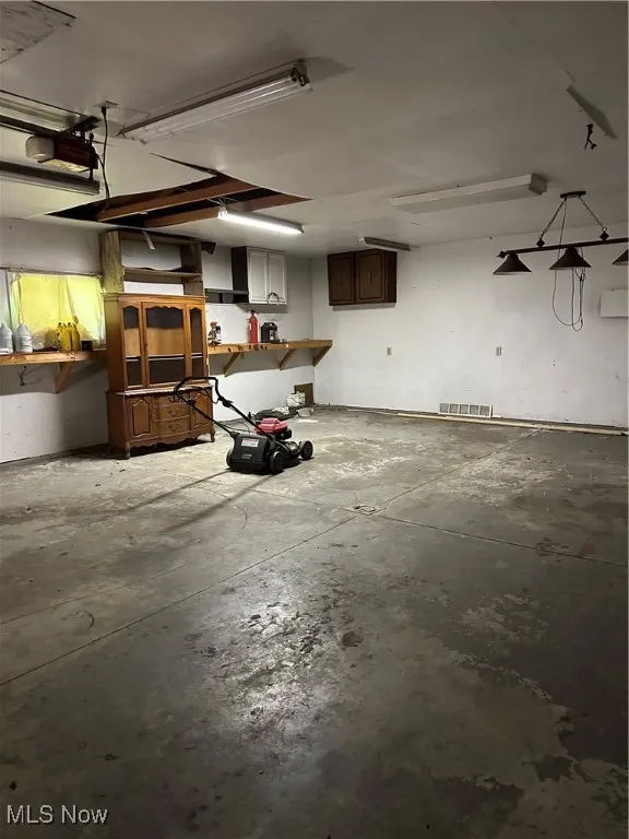 Garage featuring a workshop area and a garage door opener